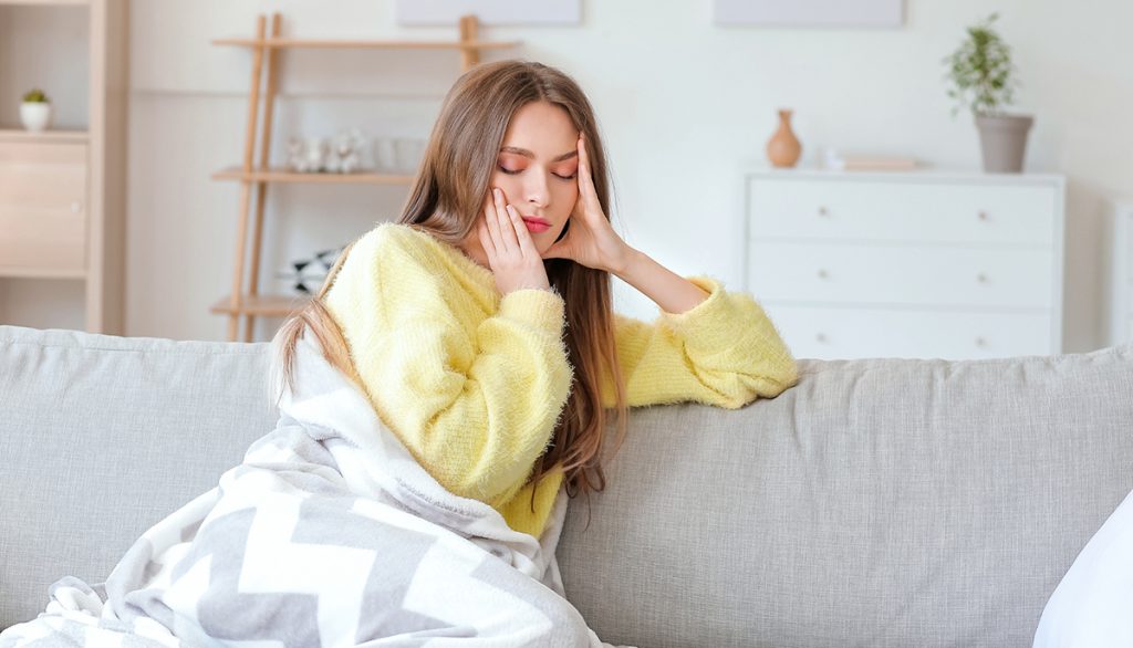 Frau ist müde und sitzt auf dem Sofa
