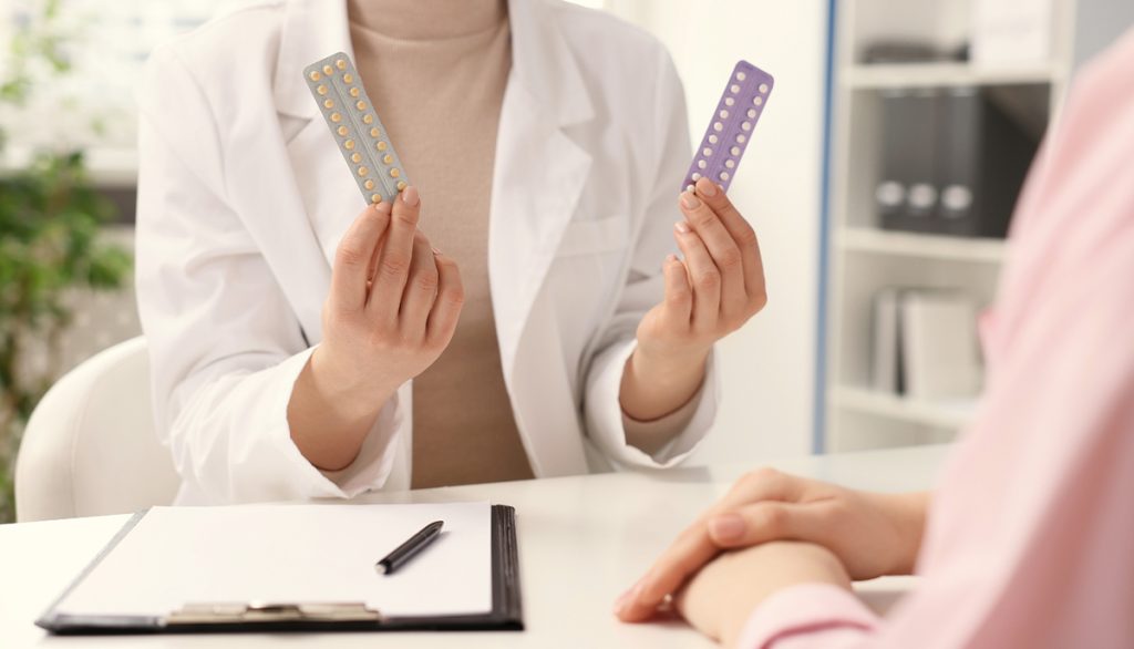 Frau in der Sprechstunde, Ärztin mit Hormonpräparaten in der Hand