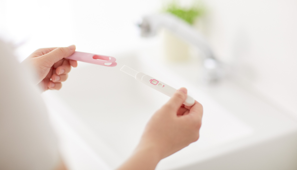 Frau mit Schwangerschaftstest in der Hand