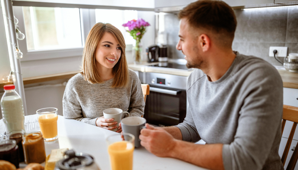 Ein Paar am Küchentisch, das zusammen spricht.