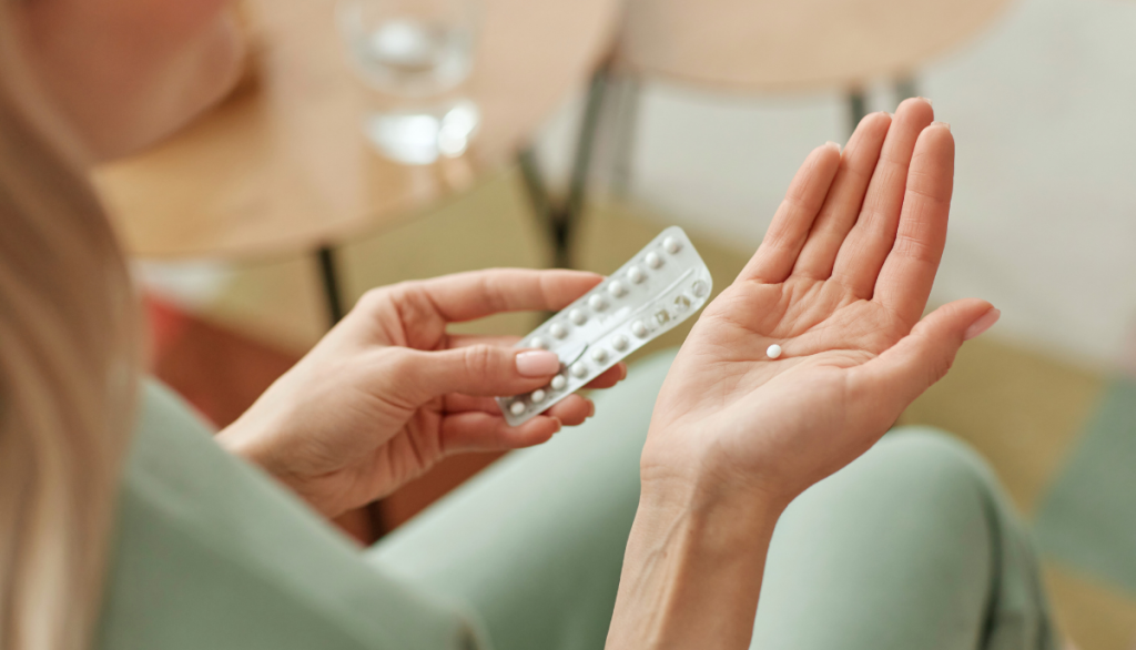 Frau mit hormonellem Verhütungsmittel in der Hand