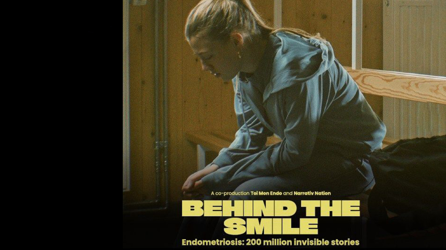 Filmszene aus dem Kurzfilm Behind the Smiles mit einer jungen Person in einem Klassenzimmer