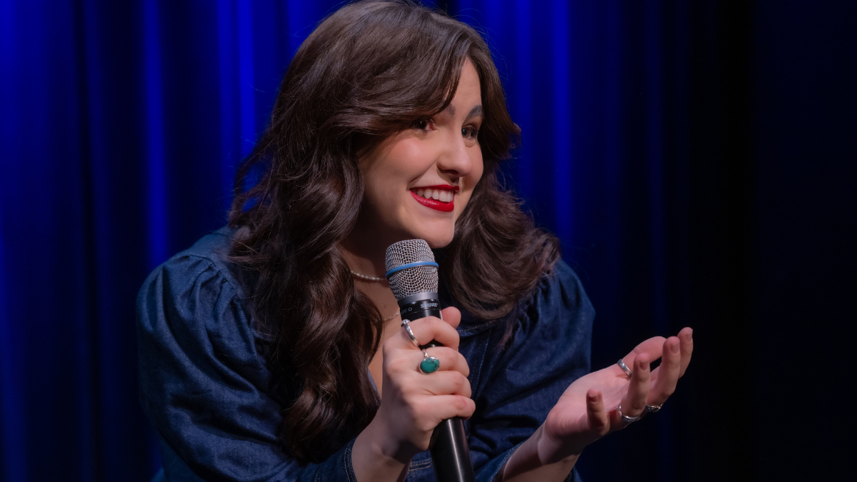 Comedienne auf einer Bühne mit Mikrofon als Symbolbild für den EndoWeek Abend mit Kurzfilm und Comedy